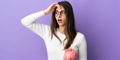 stressed out young lady holding piggy bank